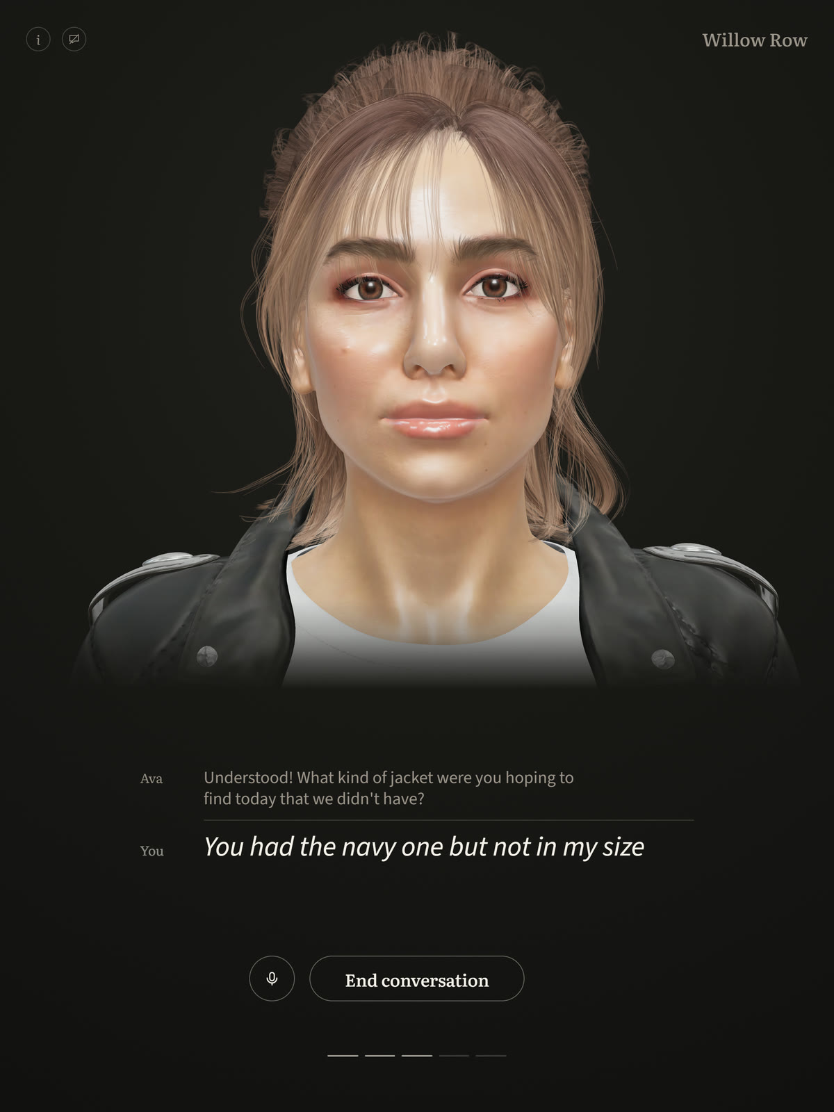 Lyra's customer screen on a tablet, Willow Row in the corner: Ava, a woman with tied-back auburn hair in a leather jacket, listening. Beneath her the band shows her question, Understood! What kind of jacket were you hoping to find today that we didn't have?, and under it the customer's reply, You had the navy one but not in my size.